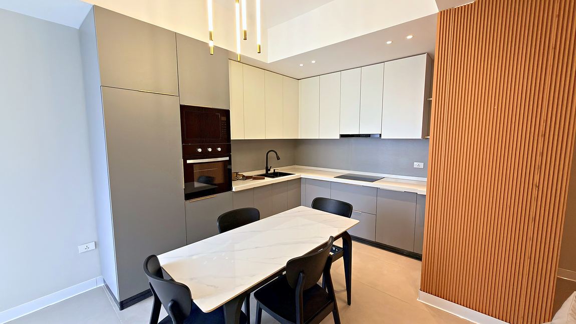 Kitchen with fitted cabinets, oven and a dining table