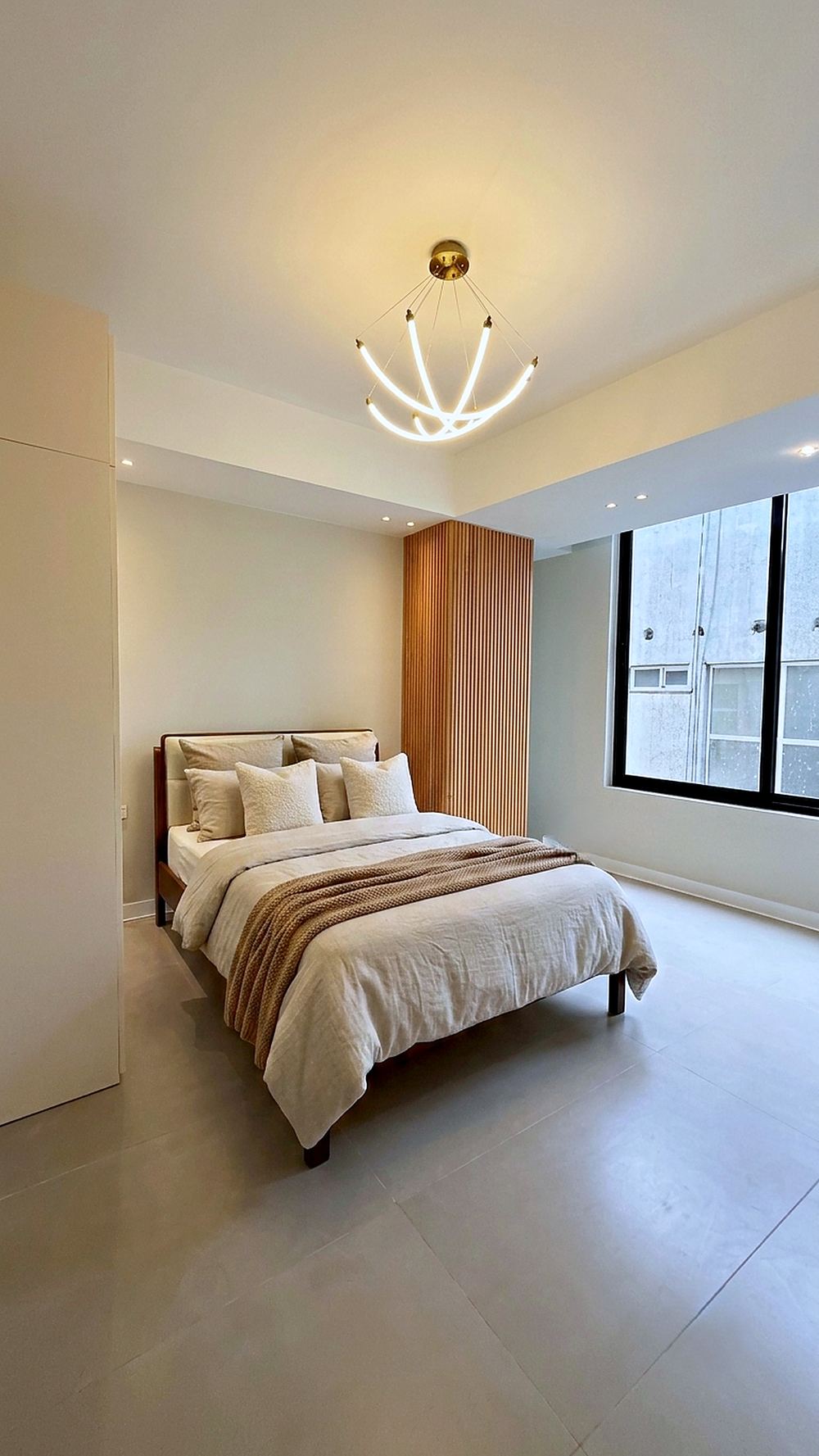 Bedroom with a slatted timber panel behind the bed