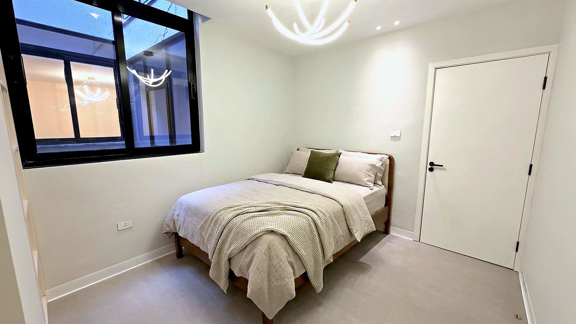 Second bedroom with a linen dressed bed