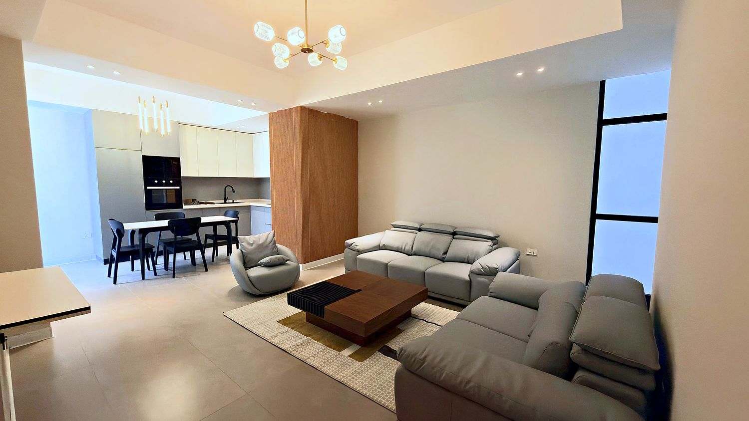 Two bedroom apartment with a leather seating group, dining table and open kitchen